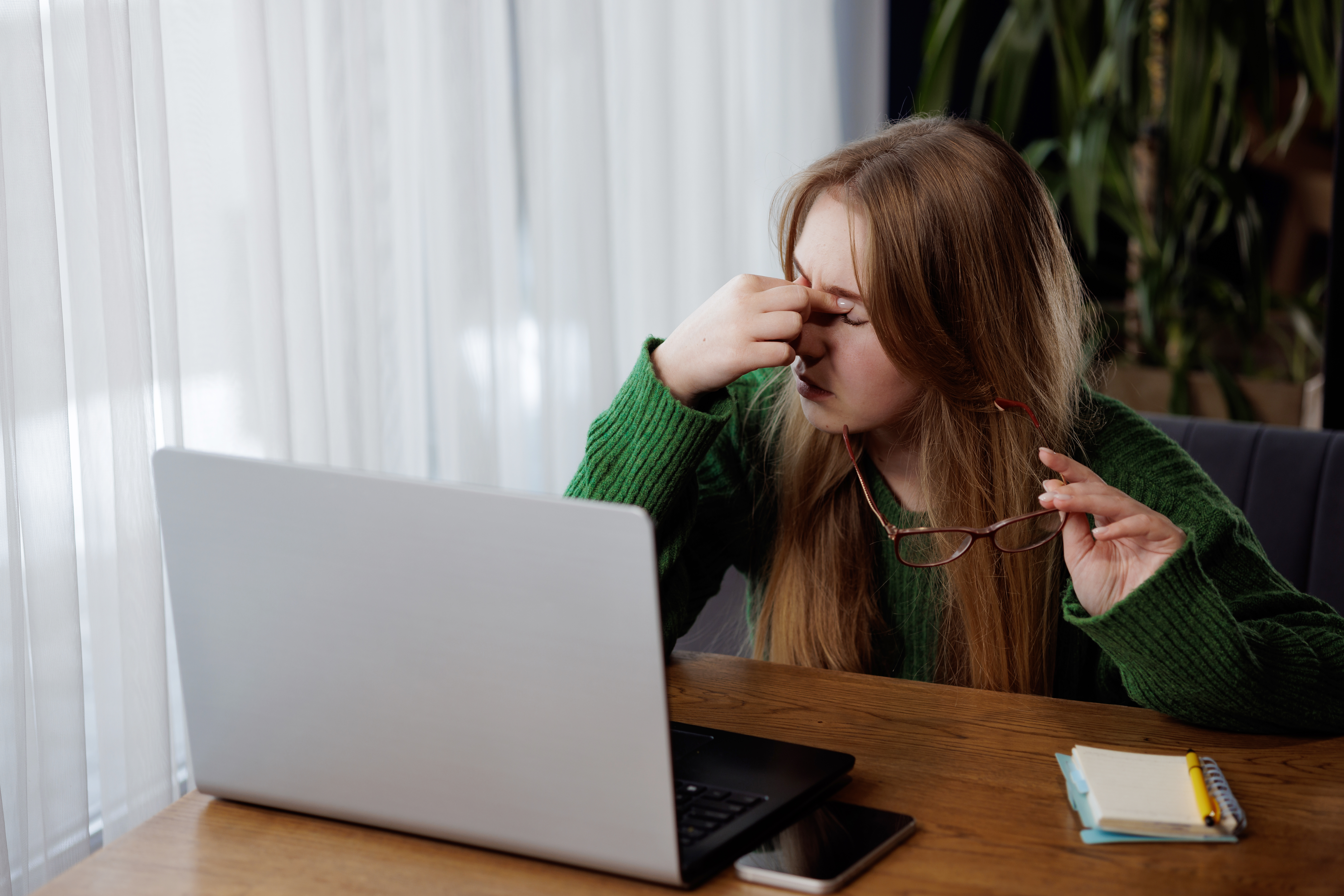 Eye strain from screen exposure: woman rubbing her eyes